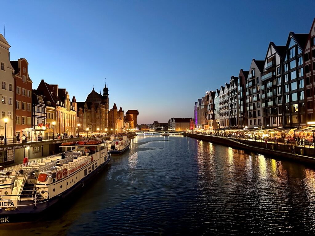 eduta del centro storico di Danzica al tramonto con i canali e le case anseatiche colorate